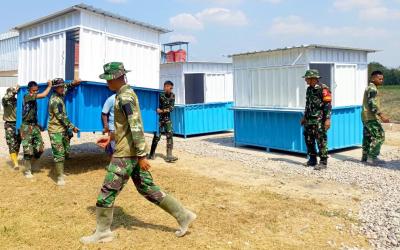 Personel Satgas TMMD ke-129 Kodim 0813/Bojonegoro bersama masyarakat saat memindahkan dan menempatkan enam unit booth container UMKM di Rest Area Terpadu Desa Kesongo, Kecamatan Kedungadem, Kabupaten Bojonegoro, Senin (10/8/2026). Foto: Deni Flamboyan/Sumber TMMD Bojonegoro