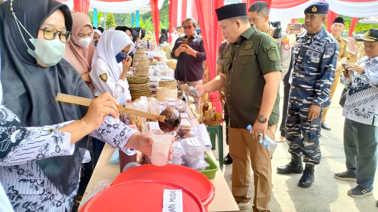 Meninjau makanan yang dijajakan peserta lomba.