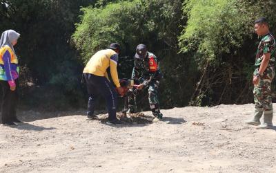 Babinsa Desa Kesongo Serka Lasmidi bersama petugas DLH Kabupaten Bojonegoro menyiapkan lubang tanam pohon di kawasan tanggul sungai Desa Kesongo dalam rangkaian TMMD ke-129.