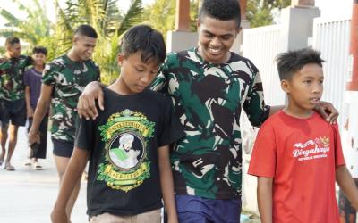 Kehangatan antara prajurit TNI dan masyarakat terlihat ketika sejumlah anggota Satgas berjalan berdampingan dengan anak-anak desa. Suasana santai dan penuh canda menjadi gambaran kedekatan yang terjalin selama pelaksanaan program TMMD.