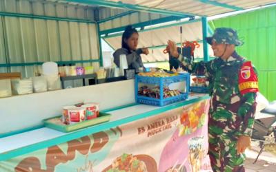 Babinsa Desa Kesongo Serka Lasmidi mendampingi pelaku UMKM saat menempati booth container di kawasan Rest Area Terpadu Desa Kesongo, Kecamatan Kedungadem, Kabupaten Bojonegoro, Selasa (11/8/2026). Foto: Deni Flamboyan/Sumber TMMD Bojonegoro