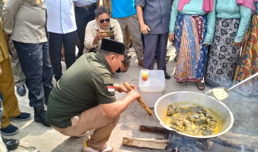 Tampak Bupati Seluma sedang menyalakan tungku untuk memasak gulai khas seluma.