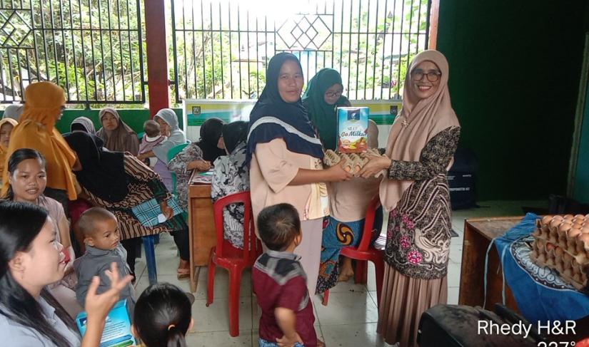 Pembagian makanan sehat dan susu untuk warga oleh ketua PKK desa kembang manis secara simbolis