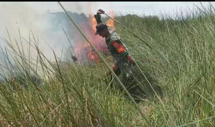 Anggota TNI ikut serta memasang kan api dengan alat seadanya