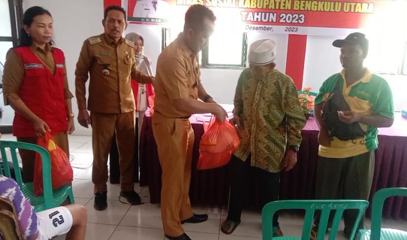 Kepala Dinas Sosial meyerahkan bantuan secara simbolis kepada warga penerima bantuan 