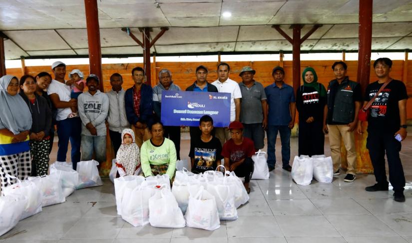 Corpcomm XL Axiata West Region, Aldi Desmet (tengah baju putih) dan Ketua Pewarta Foto Indonesia (PFI) Medan, Riski Cahyadi (paling kanan) saat menyalurkan bantuan untuk para korban bencana longsor yang melanda Desa Semangat Gunung, Kabupaten Karo, Sumatera Utara, Kamis (19/12).