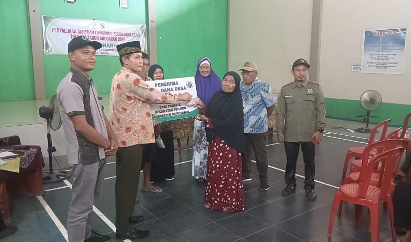 Kepala Desa Penarik menyerahkan BLT-DD kepada masyarak desa setempat, Kamis (9/4/2026). (PenaRafflesia.Com) 