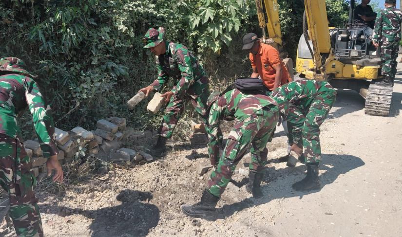 Personel Satgas TMMD ke-129 Kodim 0813 Bojonegoro bersama warga mulai membongkar paving lama sebagai langkah awal pembangunan jalan cor beton yang akan meningkatkan akses transportasi di wilayah tersebut.