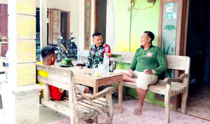 Serka Lasmidi, Babinsa Desa Kesongo, berbincang bersama warga di teras rumah dalam suasana penuh keakraban di sela pelaksanaan TMMD ke-129 Kodim 0813/Bojonegoro, Desa Kesongo, Kecamatan Kedungadem, Kamis (6/8/2026). Foto: Deni Ari Pandi/Sumber TMMD Bojonegoro.