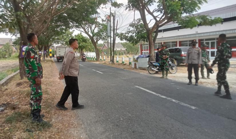 Personel Polsek Kedungadem turun langsung mengamankan proses pembongkaran bangunan lama yang akan disulap menjadi kawasan pujasera (rest area) lengkap dengan mushala dan toilet umum, Sabtu (18/7/2026).