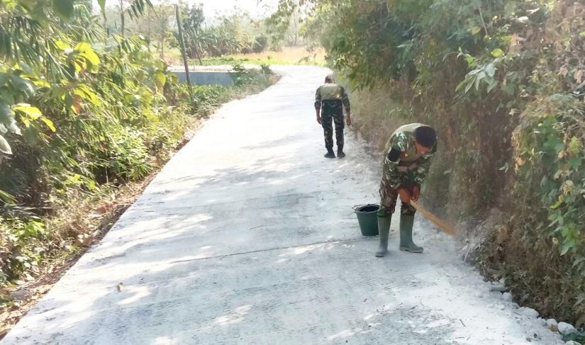  Personel Satgas TMMD ke-129 Kodim 0813/Bojonegoro membersihkan sisa material di jalan hasil pembangunan TMMD di Dusun Kedungpandan, Desa Kesongo, Kecamatan Kedungadem, Kabupaten Bojonegoro.