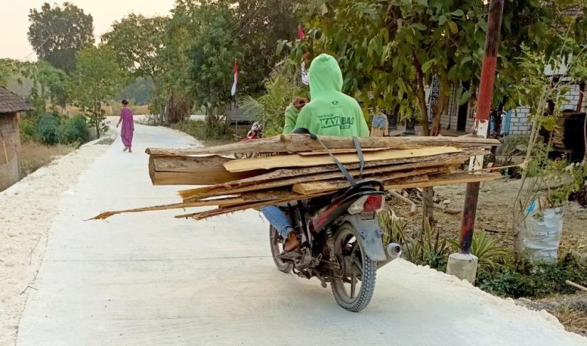  Warga melintas di jalan cor beton hasil pembangunan program TMMD ke-129 Kodim 0813/Bojonegoro di Dusun Mundu, Desa Kesongo, Kecamatan Kedungadem, Kabupaten Bojonegoro, Selasa (11/8/2026). Foto: Deni Flamboyan/Sumber TMMD Bojonegoro
