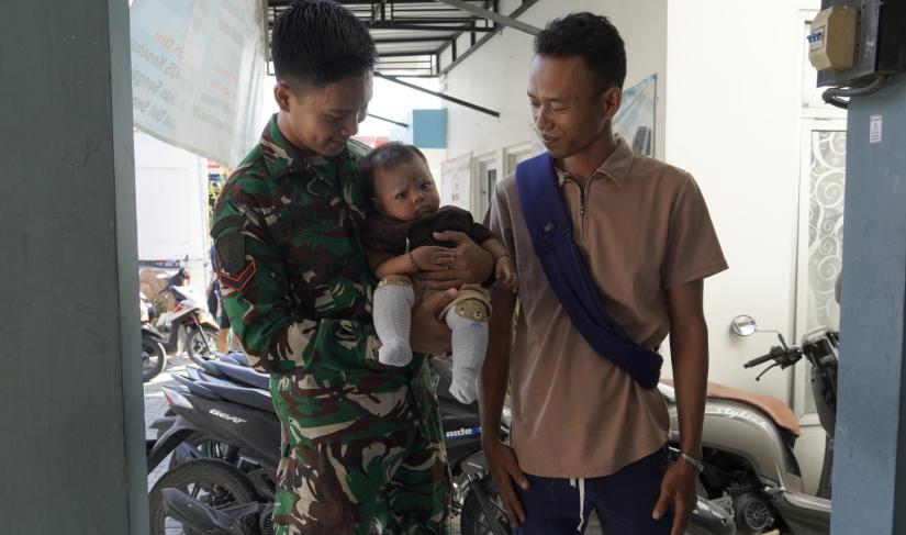 Hangat di Tengah Pengabdian: Serda Fauzi Zeyd Abdillah, anggota Satgas TMMD ke-129 Kodim 0813 Bojonegoro, menggendong balita warga di sela aktivitas pembangunan TMMD di Desa Kesongo, Kecamatan Kedungadem, Kabupaten Bojonegoro, Kamis (6/8/2026). Momen tersebut menjadi gambaran kedekatan dan kemanunggalan TNI dengan masyarakat.