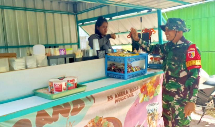 Babinsa Desa Kesongo Serka Lasmidi mendampingi pelaku UMKM saat menempati booth container di kawasan Rest Area Terpadu Desa Kesongo, Kecamatan Kedungadem, Kabupaten Bojonegoro, Selasa (11/8/2026). Foto: Deni Flamboyan/Sumber TMMD Bojonegoro