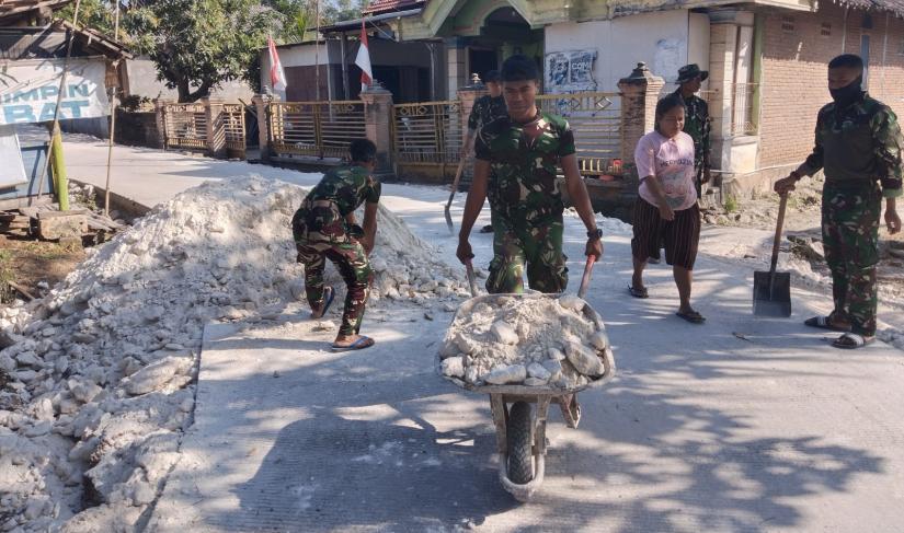 Satgas TMMD ke-129 Kodim 0813/Bojonegoro bersama warga mengangkut dan meratakan material pedel untuk memperkuat bahu jalan cor di Dusun Mundu, Desa Kesongo, Kecamatan Kedungadem, Kabupaten Bojonegoro.