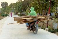  Warga melintas di jalan cor beton hasil pembangunan program TMMD ke-129 Kodim 0813/Bojonegoro di Dusun Mundu, Desa Kesongo, Kecamatan Kedungadem, Kabupaten Bojonegoro, Selasa (11/8/2026). Foto: Deni Flamboyan/Sumber TMMD Bojonegoro