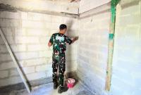 Dinding bata ringan yang sebelumnya tampak sederhana kini mulai terlihat lebih rapi setelah mendapat sentuhan tangan para prajurit Satgas TNI Manunggal Membangun Desa (TMMD) ke-129 Kodim 0813 Bojonegoro.